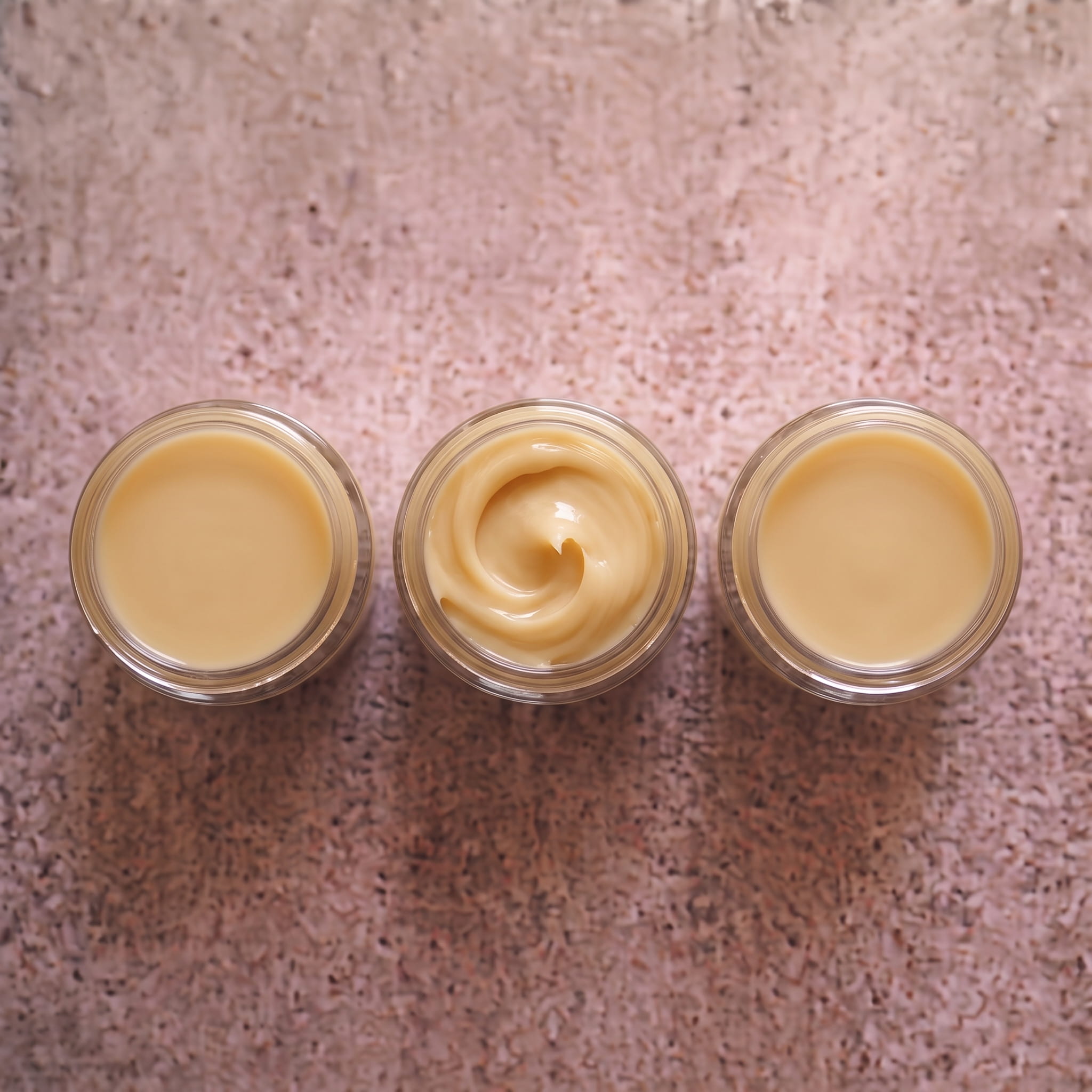 Trois pots d’essai de crème, textures lisses et travaillées